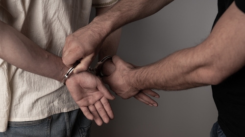 Police officers arresting a man during a Tennessee drug investigation, illustrating the need for a Murfreesboro drug crimes lawyer.
