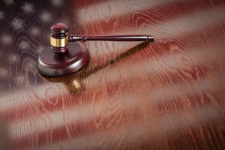 Scales of justice with gavel and American flag representing constitutional rights protection in criminal defense
