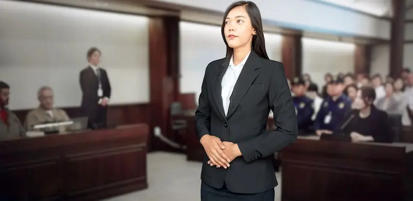 A confident female defense attorney in a black suit stands before a packed courtroom with her hands clasped representing a criminal defense lawyer from Byron Pugh Legal prepared to advocate aggressively on behalf of her client to achieve the most favorable criminal defense outcomes possible in Tennessee.