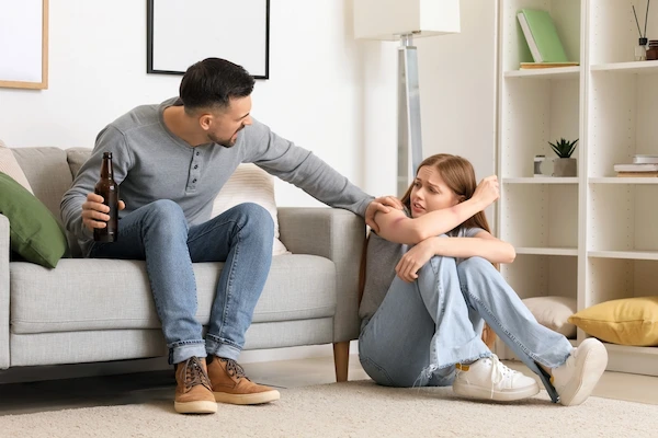 Domestic abuse concept shown with a young woman and drunk man